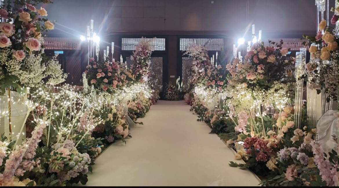 Wedding aisle lined with pastel floral arrangements and fairy lights